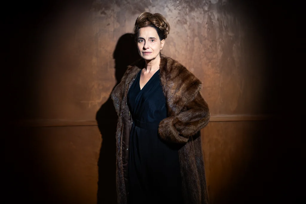 hitch-promo-alma-seule-manteau-fourrure France Parent incarne Alma Reville, debout seule en manteau de fourrure, dans un éclairage dramatique pour "Hitch".